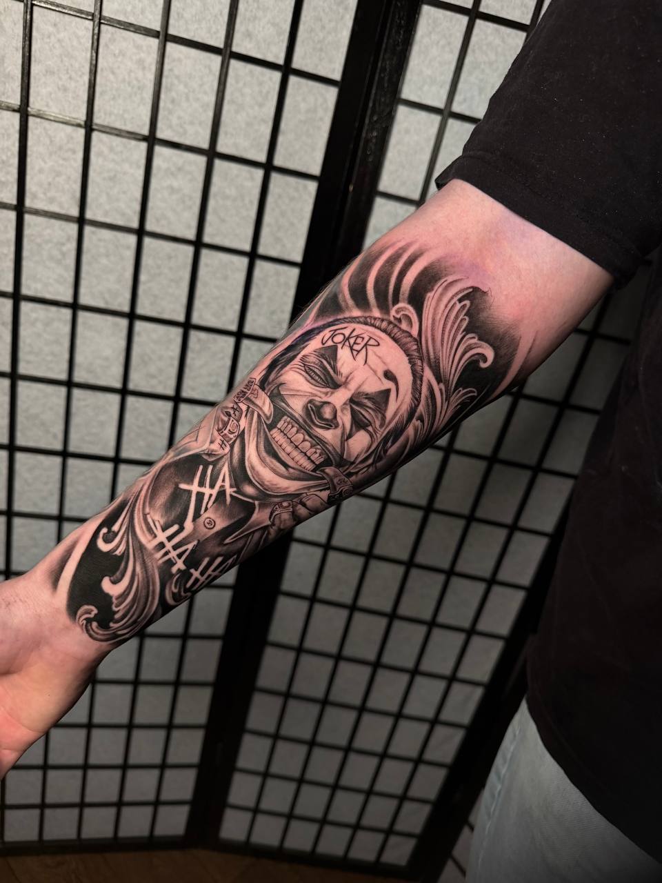 Realistisches Black-and-Grey Joker-Tattoo am Unterarm