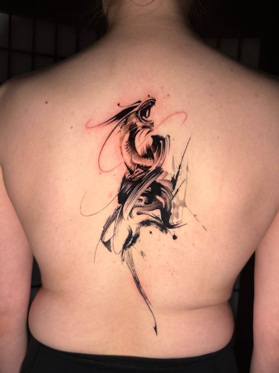 Abstraktes Schlangen-Tattoo im Ink-Brush-Stil auf dem Rücken